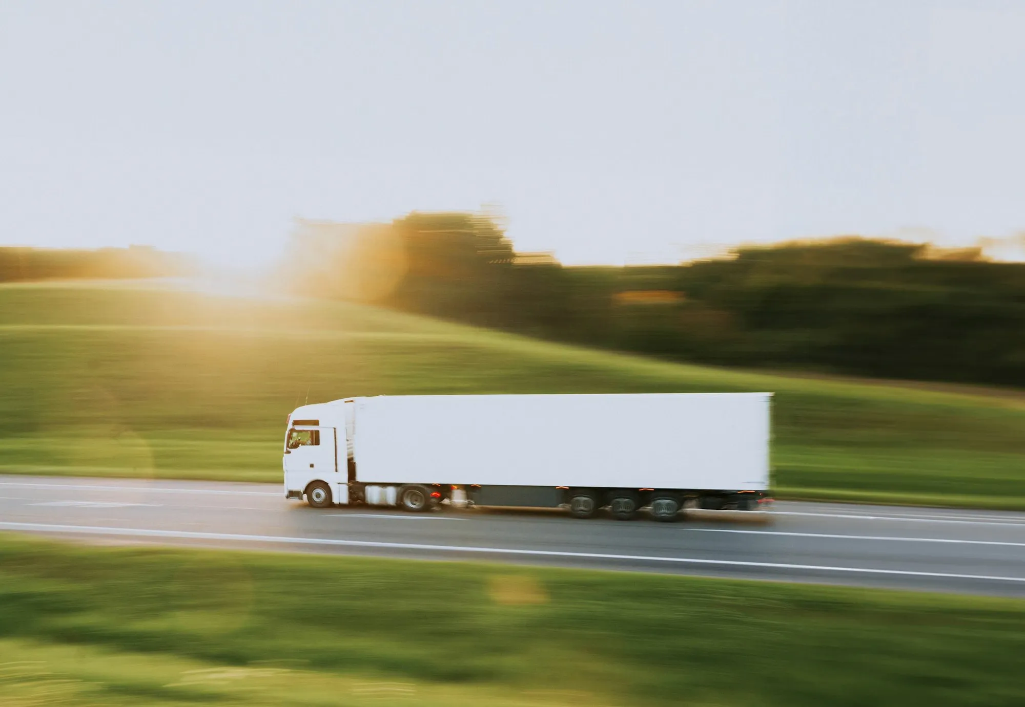 A semi-trailer on a highway at sunset